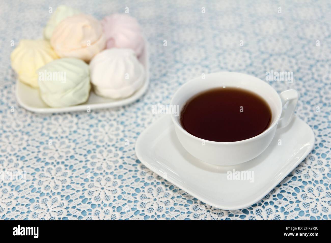 Tradizionale e delizioso tè preparato in una tazza e marshmallows d'aria si trovano sul tavolo, un dolce dessert Foto Stock