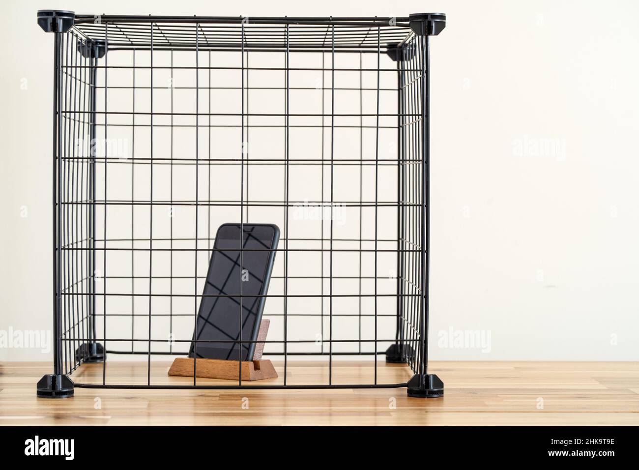 Smartphone in piedi all'interno della gabbia. Concetto di social media e internet detox. Foto Stock