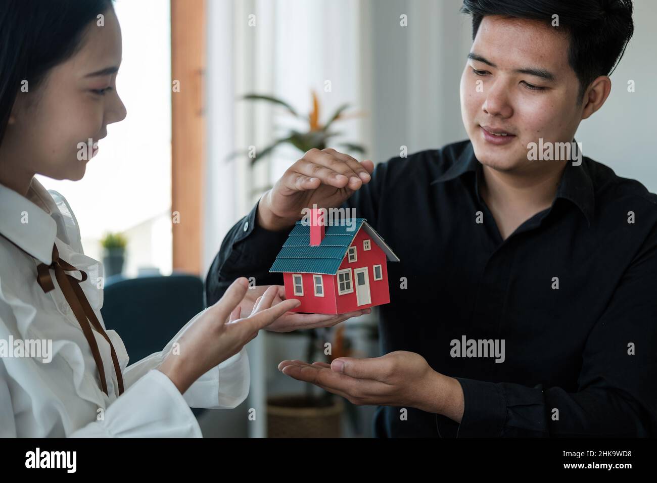 Le coppie asiatiche stanno usando le loro mani per proteggere il concetto dell'uso dei gesti negli investitori immobiliari, assicurazione di leasing, acquisto e vendite Foto Stock