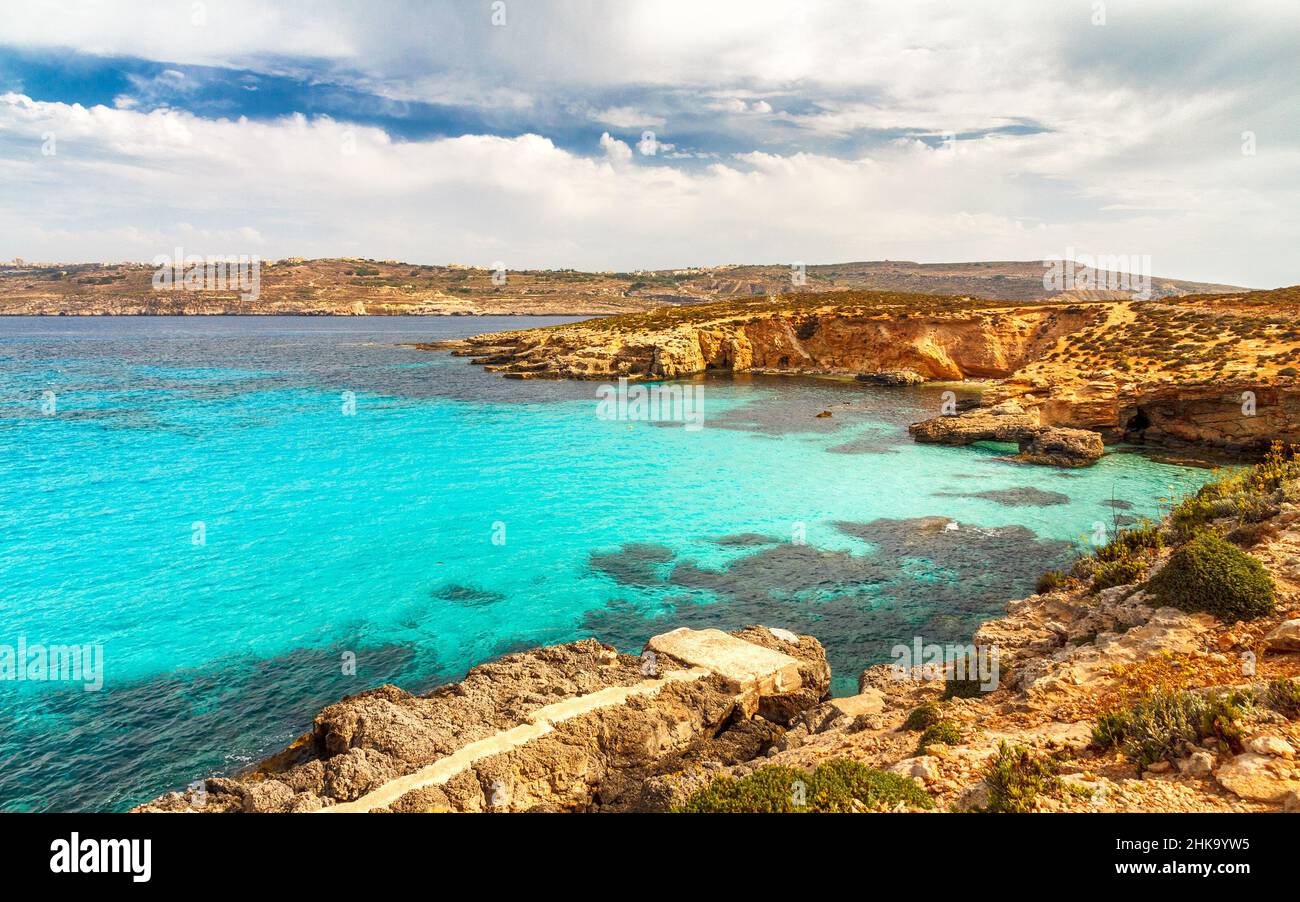 Costa rocciosa dell'isola di Comino tra le isole di Malta e Gozo nel Mediterraneo, Europa. Foto Stock