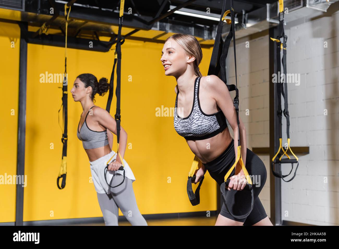 Cinghie di sospensione tiratrici sportive positive vicino a medio Oriente amico nel centro sportivo Foto Stock