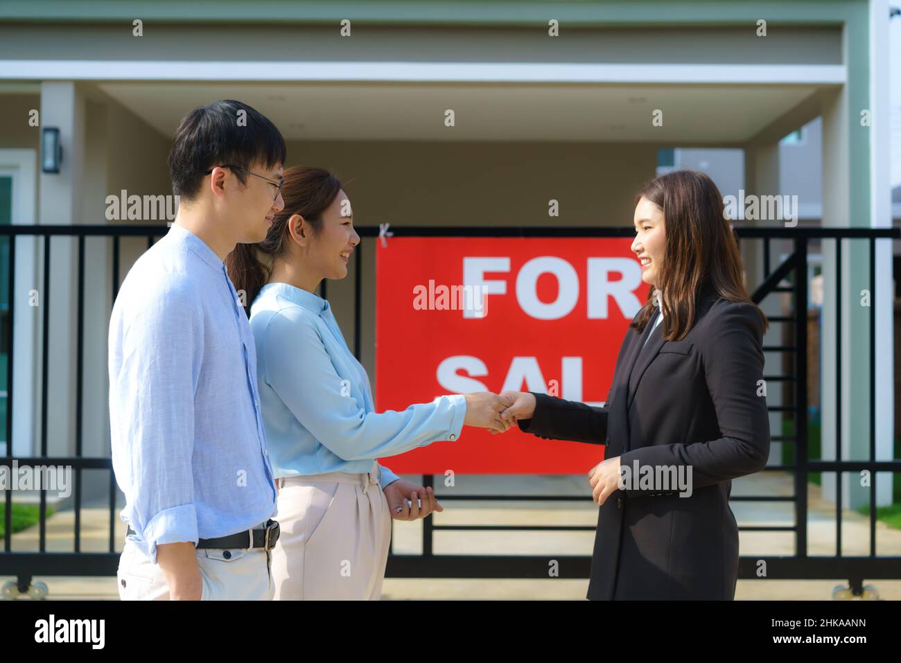Felice coppia asiatica alla ricerca della loro nuova casa e agitare le mani con broker immobiliare dopo un accordo. Giovane coppia handshaking agente immobiliare dopo Foto Stock