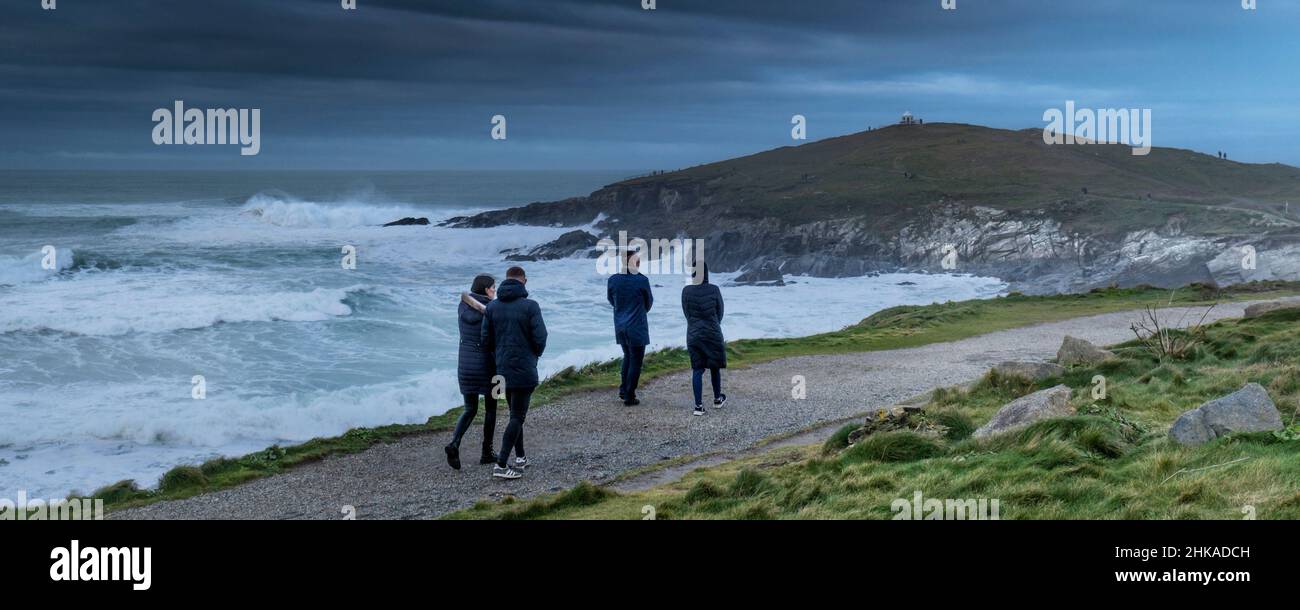 Un'immagine panoramica delle persone che camminano lungo il sentiero costiero in condizioni atmosferiche tempestose sulla costa frastagliata di Towan Head a Newquay in Cornovaglia. Foto Stock