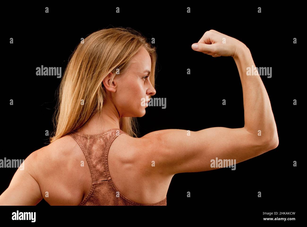 Donna con braccio sollevato, muscolo flessibile, vita in alto, vista posteriore Foto Stock
