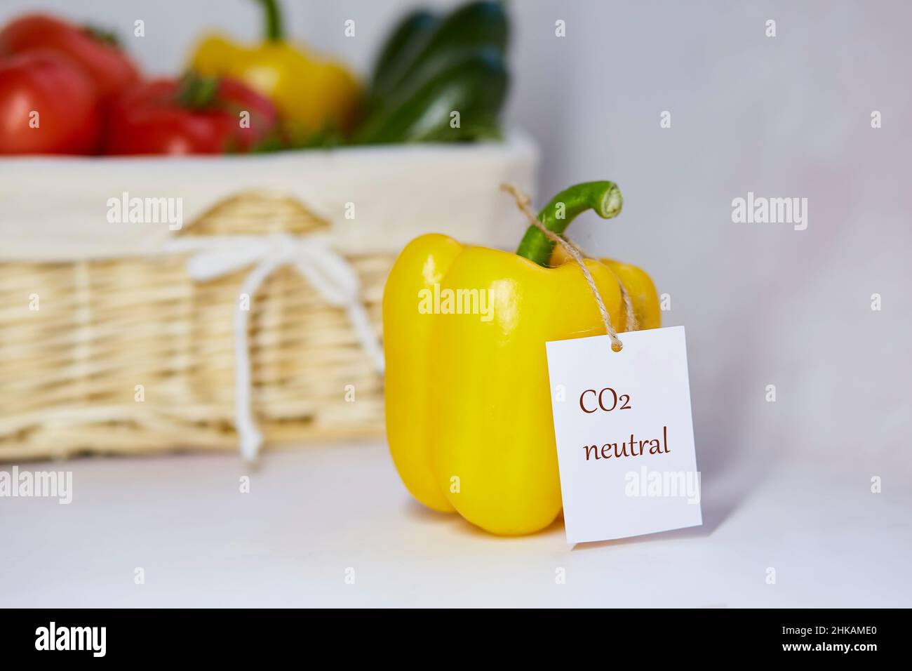 Etichetta del prodotto a carbonio neutro sul peperone. Etichettatura del carbonio. Cestino di verdure sullo sfondo. Zero emissioni di carbonio nette. Produzione agricola biologica Foto Stock