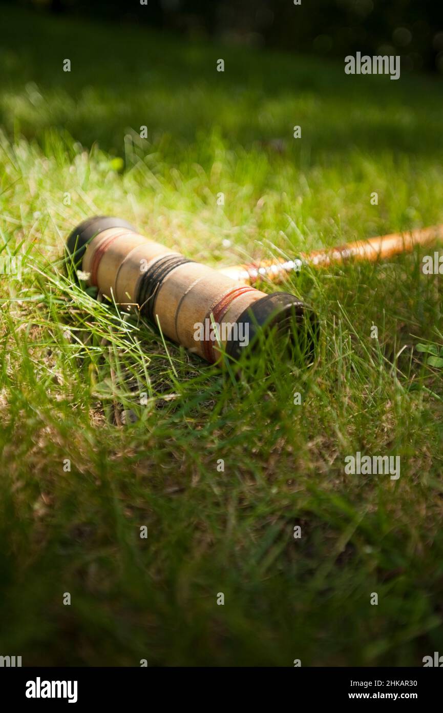 Croquet Mallet che si posa in erba Foto Stock