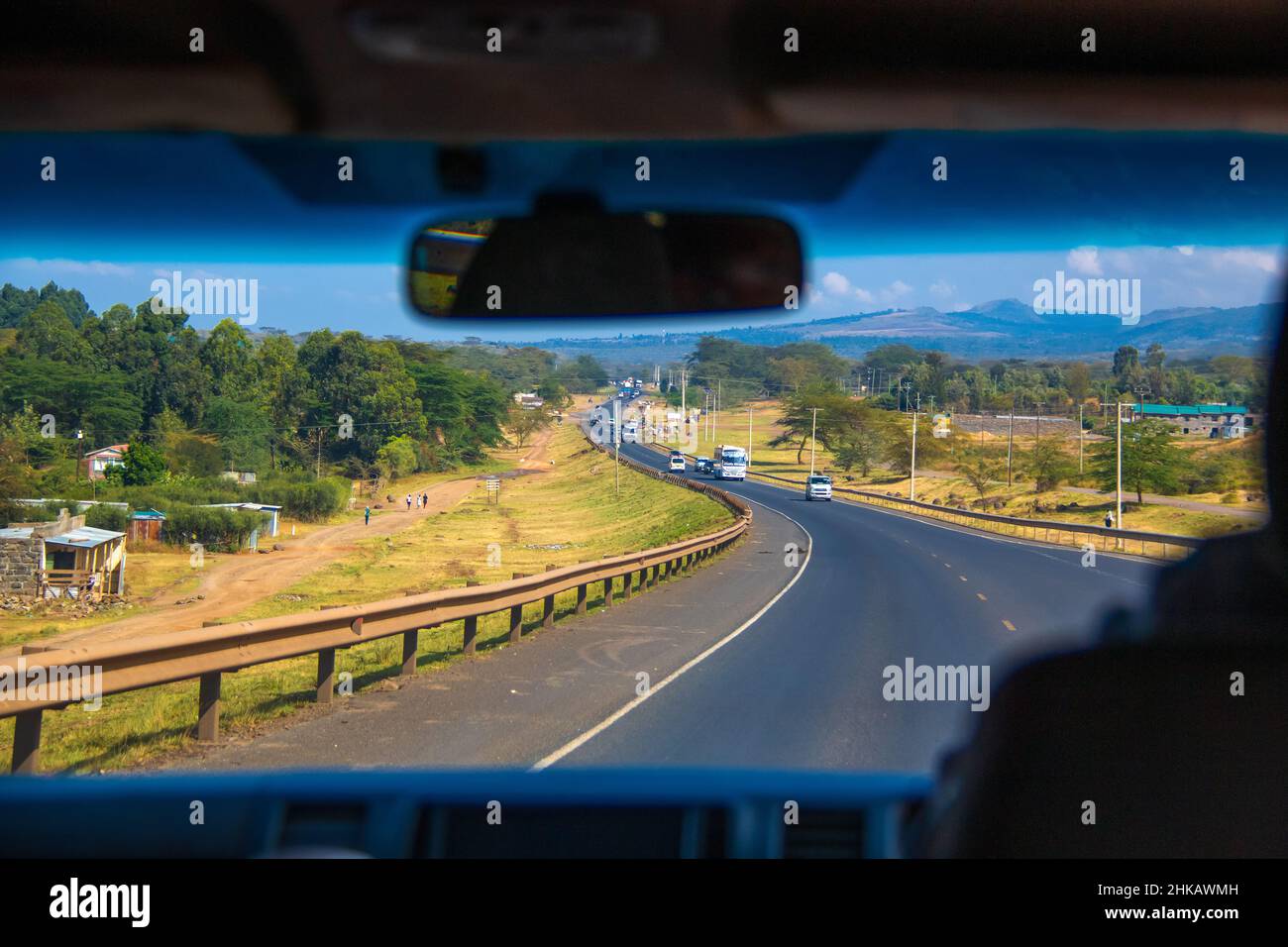 Vista dell'autista del landcape passando per un villaggio locale su un'autostrada keniana attraverso la Great Rift Valley ad ovest di Nairobi, Kenya Foto Stock