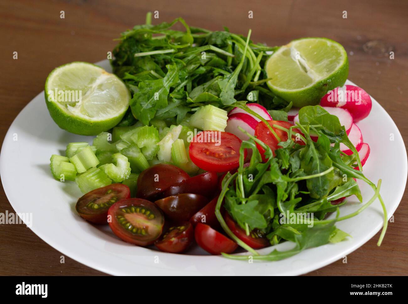 Verdure fresche come pomodoro, rafano, sedano a fette, rosmarino e lime Foto Stock