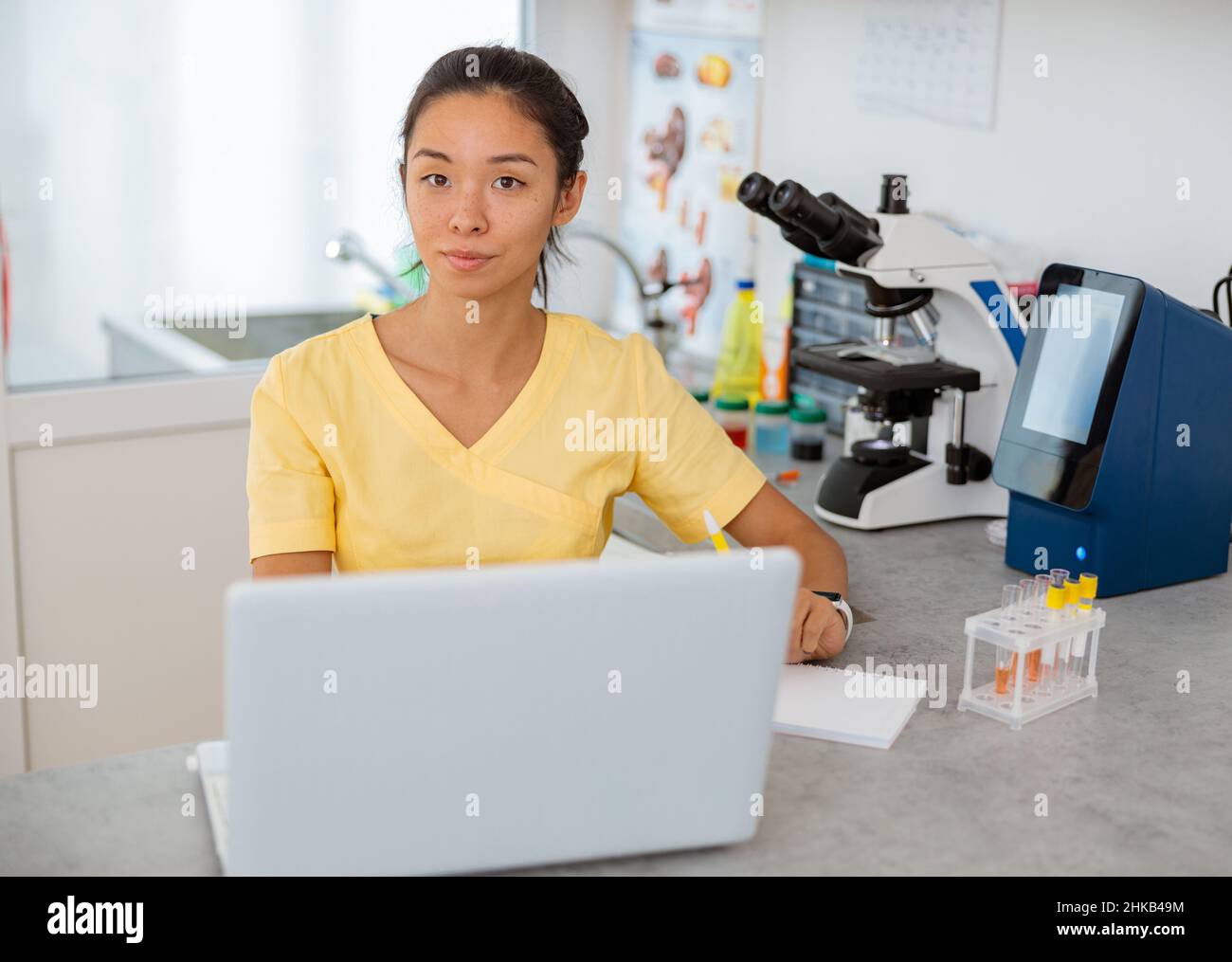 Assistente veterinario femminile utilizzando un computer portatile in laboratorio Foto Stock