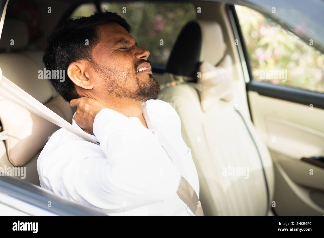 Giovane conducente indiano di cabina stanco che soffre di dolore alle articolazioni del collo a causa della guida eccessiva - concetto di artrite, stile di vita non sano, sovraccaricato e eshusted. Foto Stock
