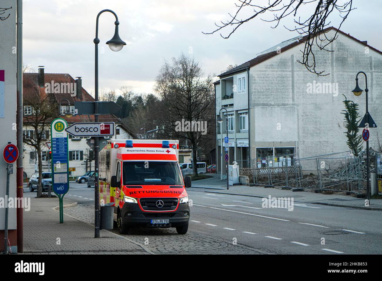 Un'ambulanza della Croce Rossa tedesca si trova a una fermata dell'autobus con i suoi fari accesi. Foto Stock