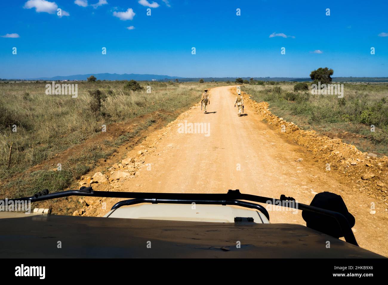 Due rangers parco fortemente armati pattugliano le strade sterrate nel Parco Nazionale di Nairobi, Kenya, per proteggere la fauna locale da bracconieri Foto Stock