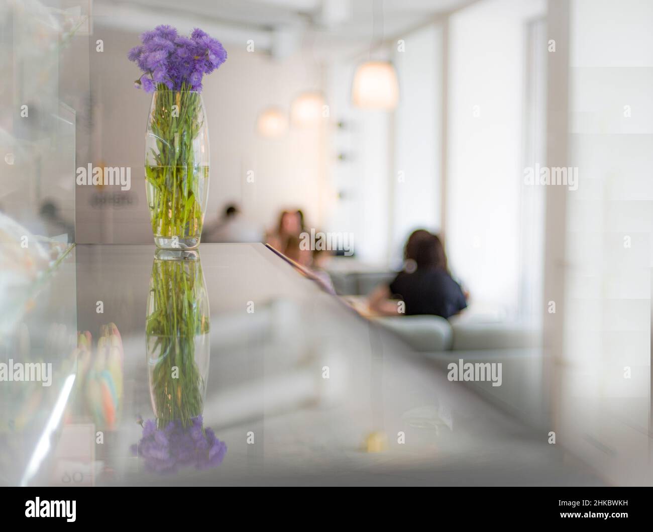 Cafe interno con vaso e fiori blu Foto Stock