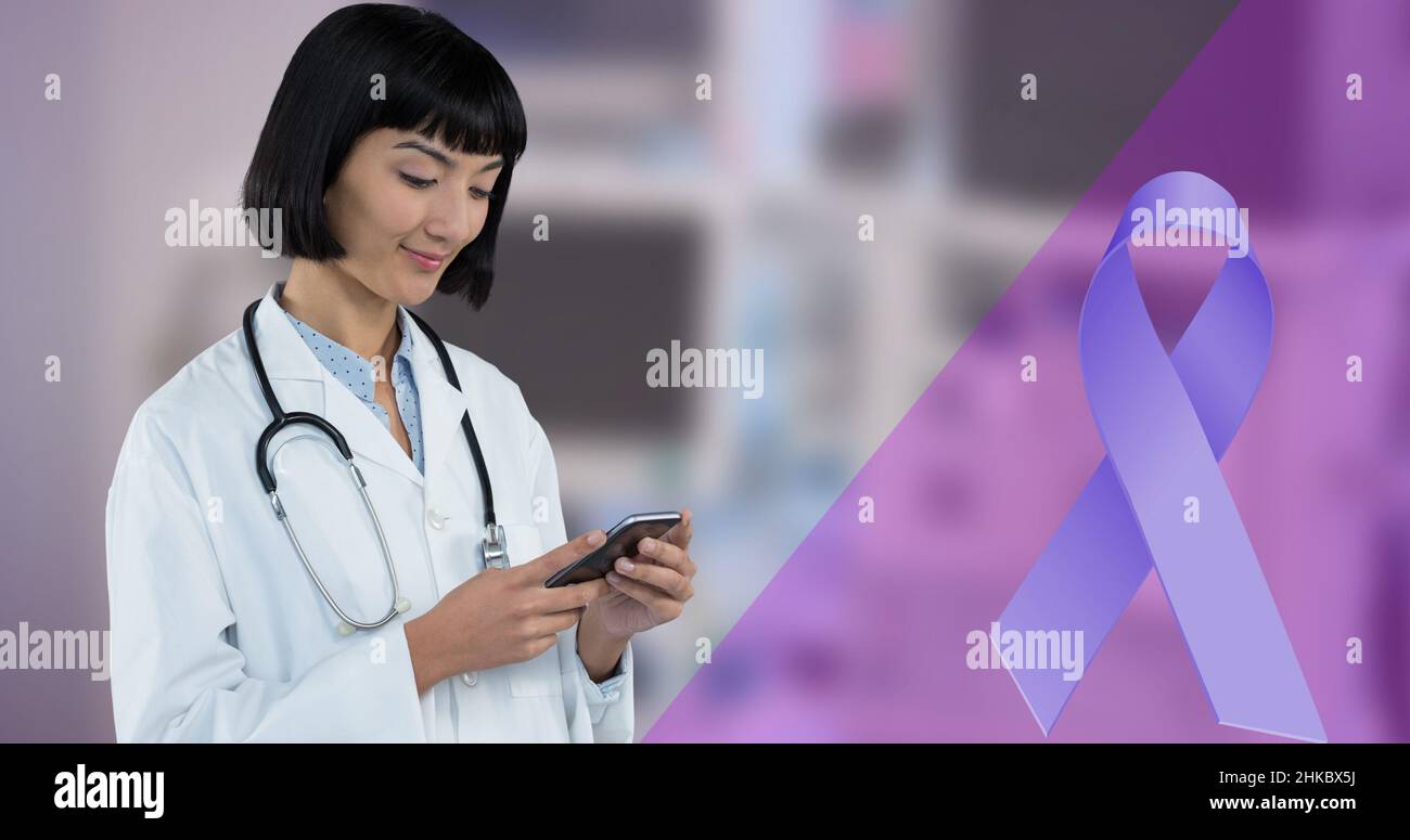 Immagine composita digitale del nastro blu e sorridente medico asiatico giovane donna utilizzando smartphone Foto Stock