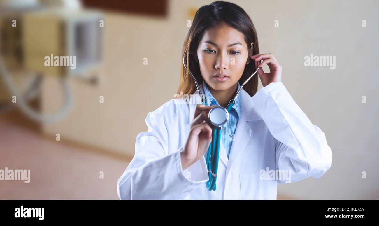 Giovane medico asiatico che esamina con stetoscopio mentre si trova in ospedale Foto Stock