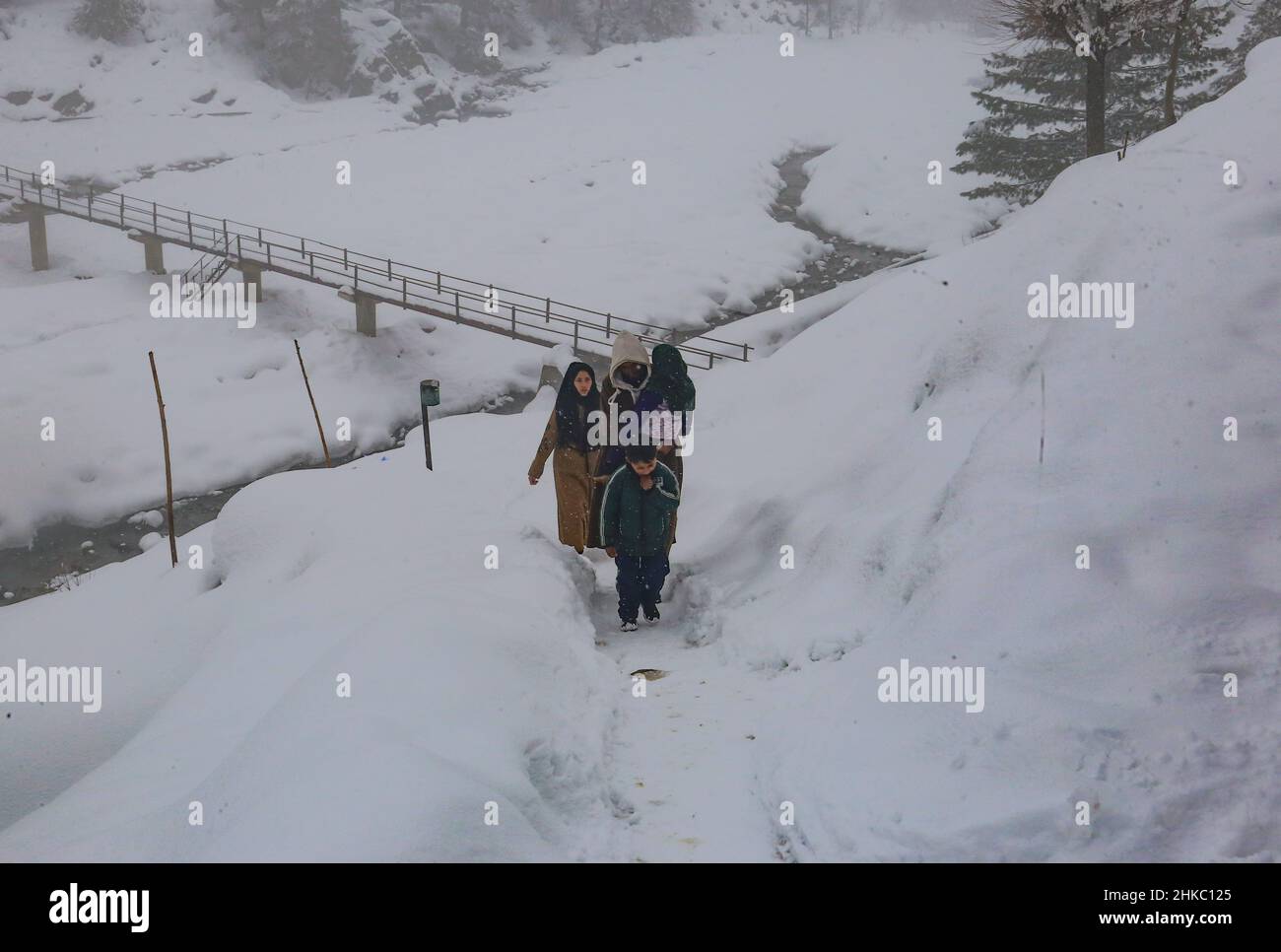 3 febbraio 2022, Srinagar, Jammu e Kashmir, India: La gente del Kashmiri cammina su una strada collinare coperta di neve in un villaggio nel distretto di Baramulla del Kashmir settentrionale, circa 35 chilometri a nord di Srinagar, la capitale estiva del Kashmir indiano. (Credit Image: © Sajad Hameed/Pacific Press via ZUMA Press Wire) Foto Stock