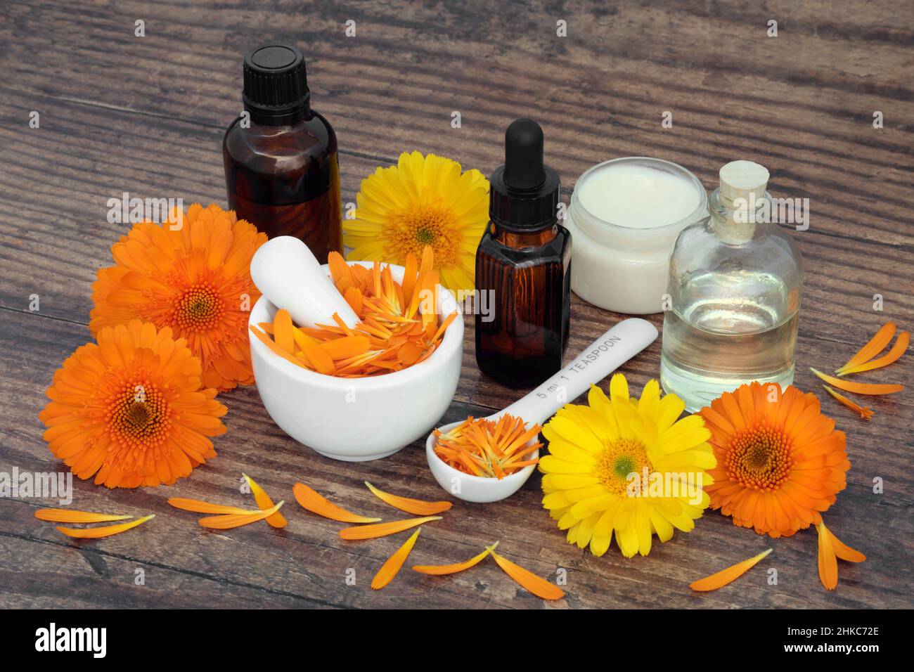 Calendula fiori per aromaterapia cura della pelle con bottiglie di olio essenziale e unguento. Guarisce ferite, acne, eczema e stimola il collagene. Foto Stock