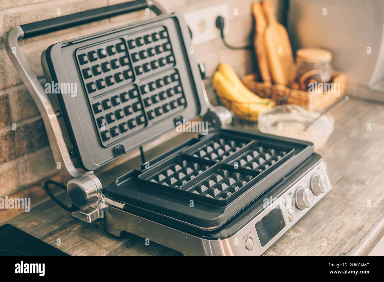 Ferro da stiro per waffle sul tavolo da cucina. Cucina interna. Foto Stock