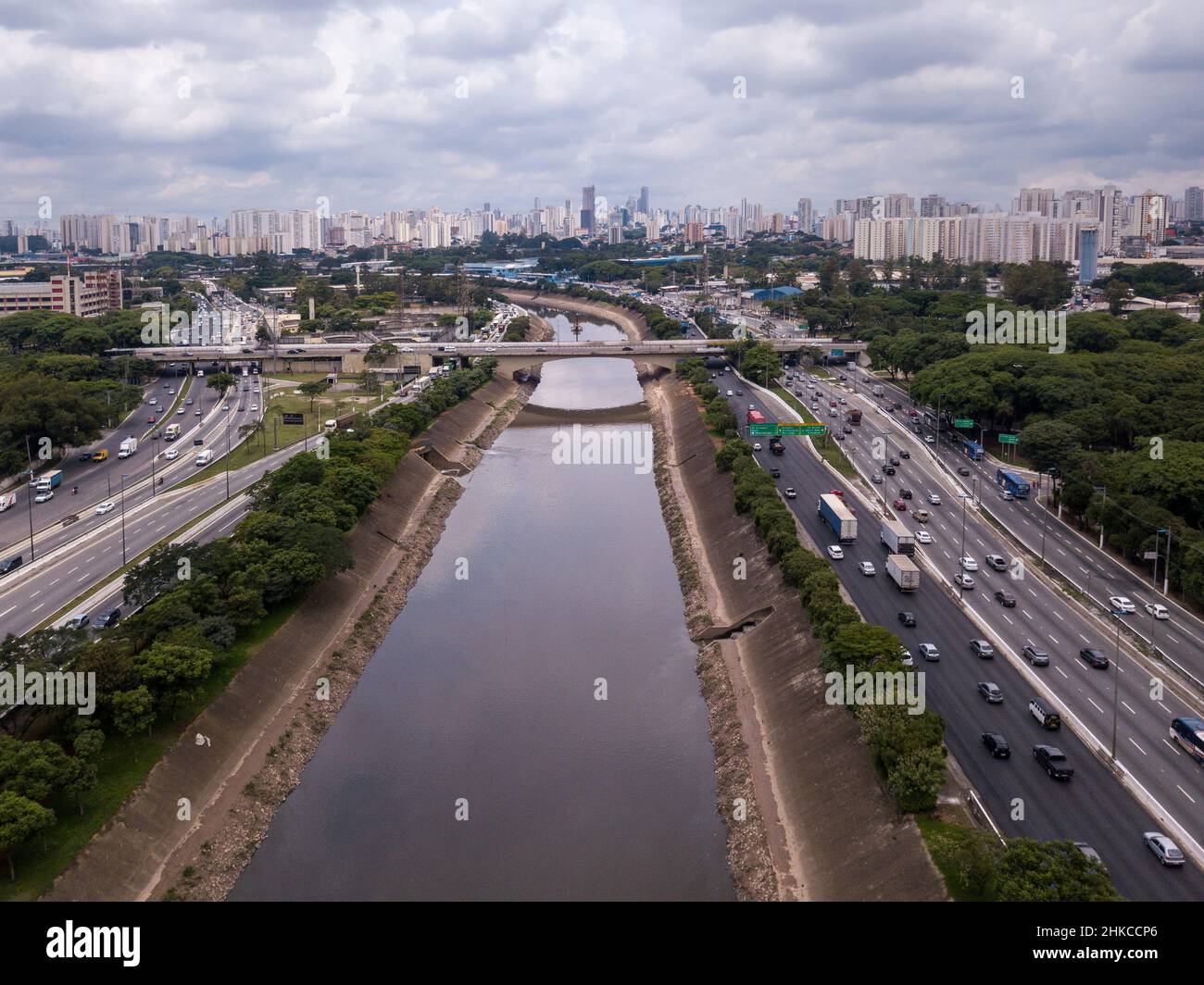 Splendida vista aerea del drone Marginal Tiete River Avenue, skyline della città di Sao Paulo in estate giorno di sole. Automobili, alberi ed edifici. Concetto di urbano. Foto Stock