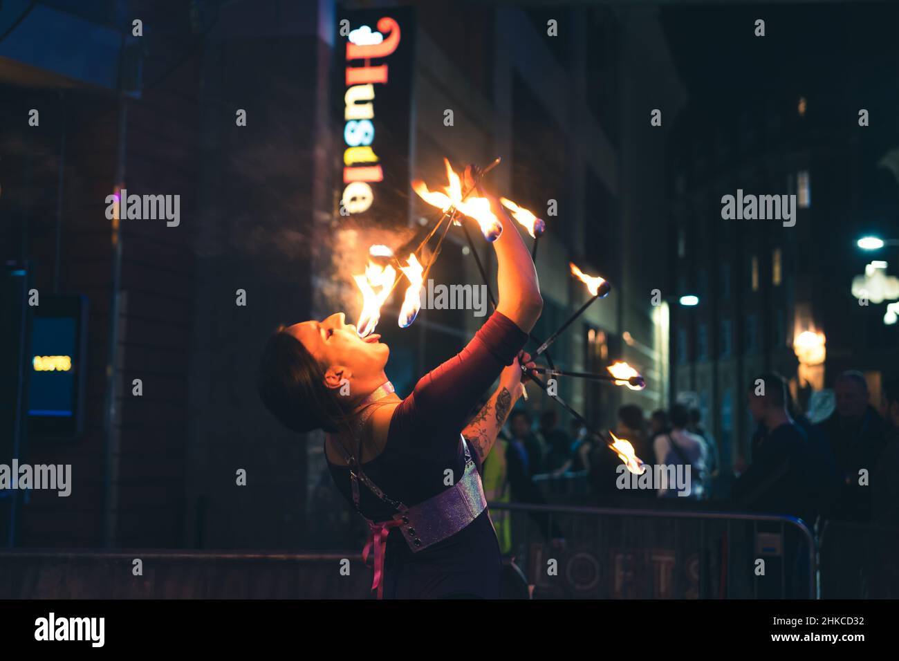 Un mangiatore di fuoco si esibisce al di fuori di uno dei locali notturni di Newcastle upon Tyne, i vivaci locali notturni del Regno Unito. Foto Stock