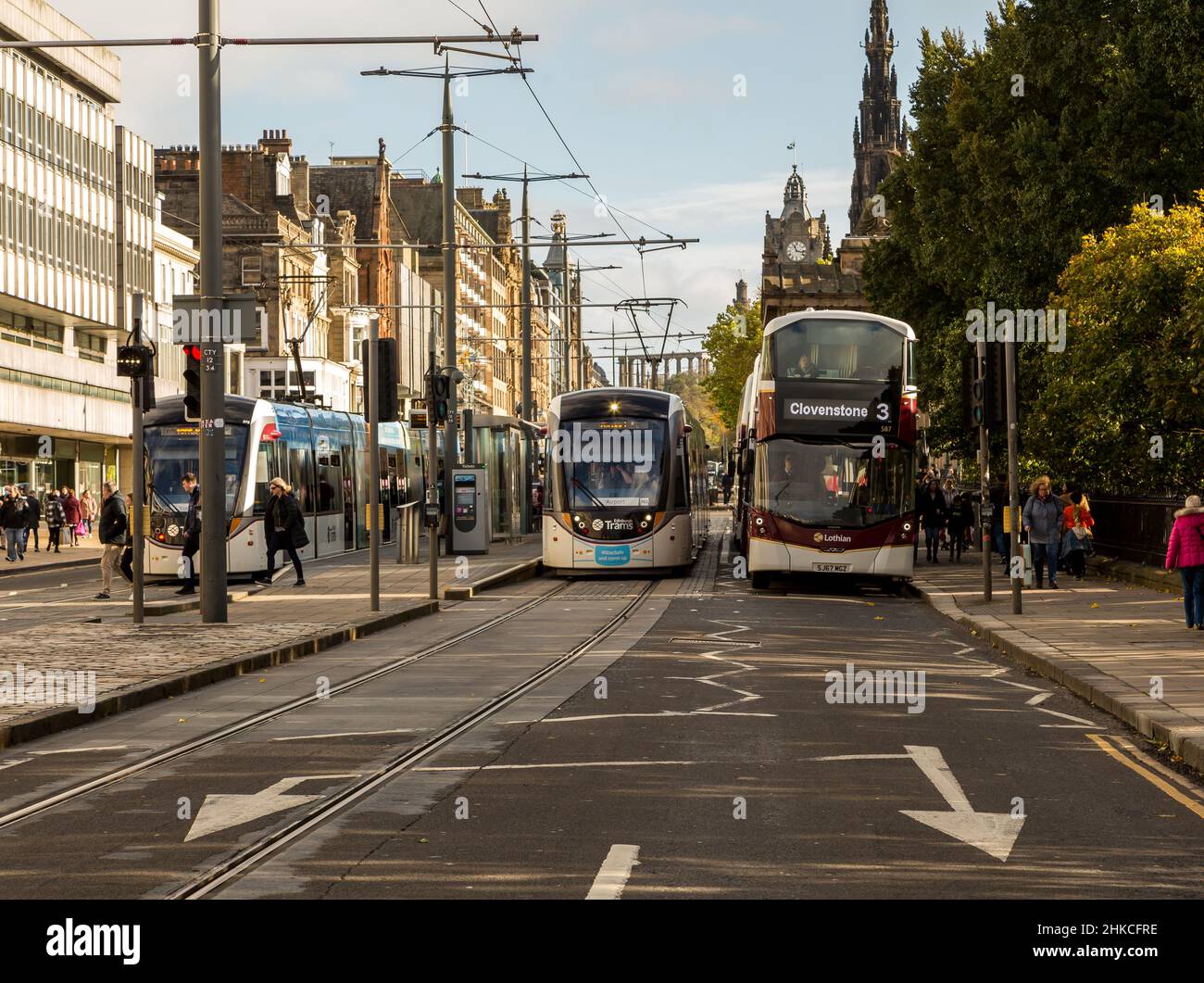 Princes Street a Edimburgo, Scozia, la tradizionale strada principale per lo shopping della città, con un tram e un autobus locali nella scena Foto Stock