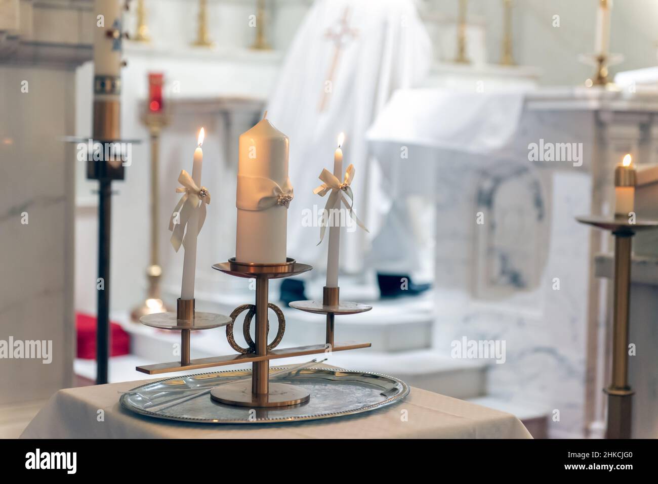 Fuochi che si innaffano su candele individuali della famiglia durante la tradizionale cerimonia cattolica per un matrimonio. Foto Stock