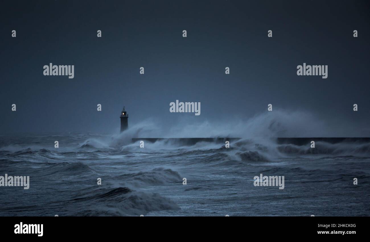 I venti della forza della balla da Storm Arwen causano le onde giganti per battere il faro e il molo nord che sorvegliano la bocca del Tyne a Tynemouth, Inghilterra Foto Stock