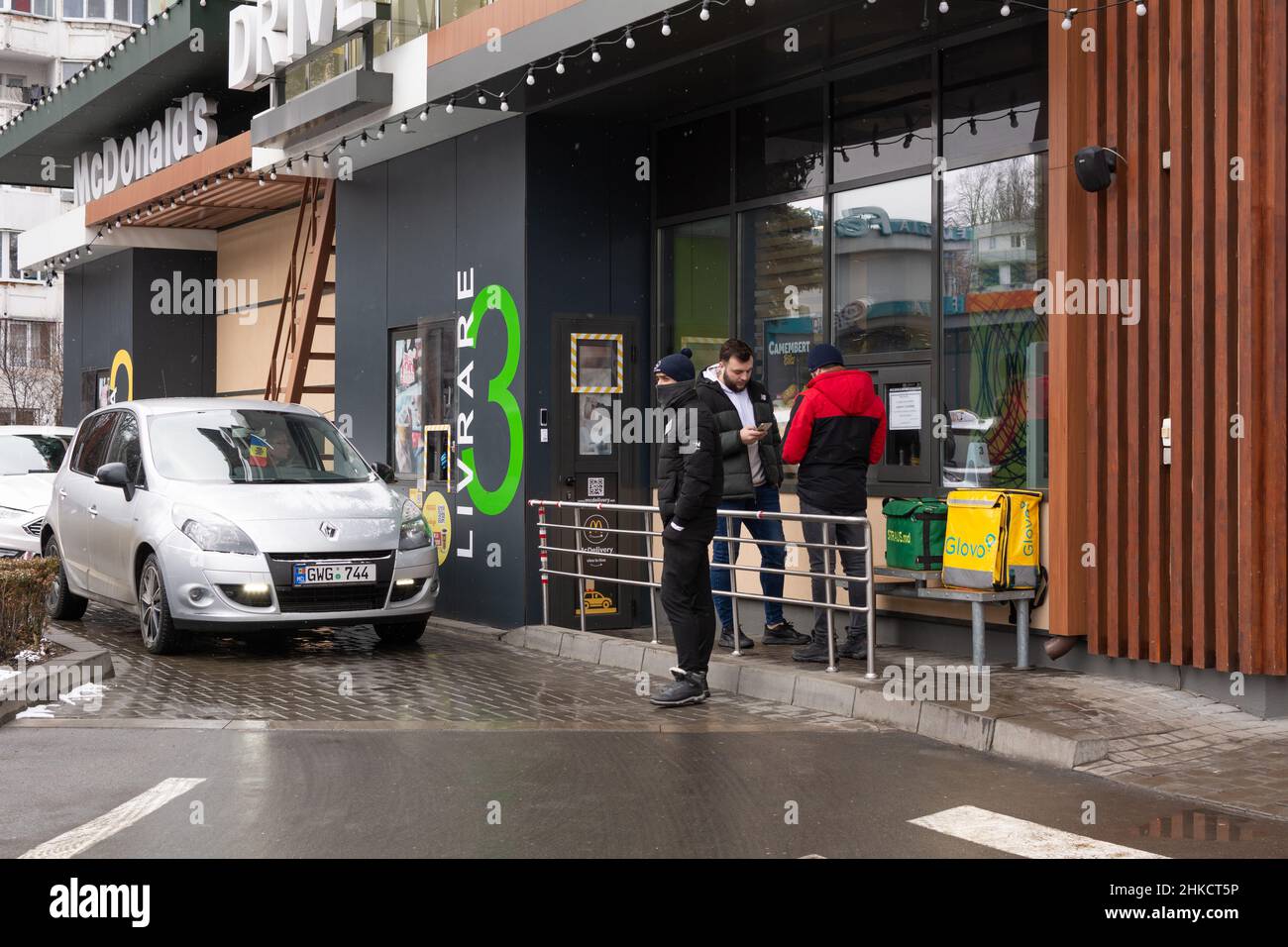 Chisinau, Moldavia - 23 gennaio 2022: McDonald's Drive. Le auto si allineano su McDonald's Drive. Il personale addetto alla consegna Glovo è in attesa della preparazione dell'ordine Foto Stock