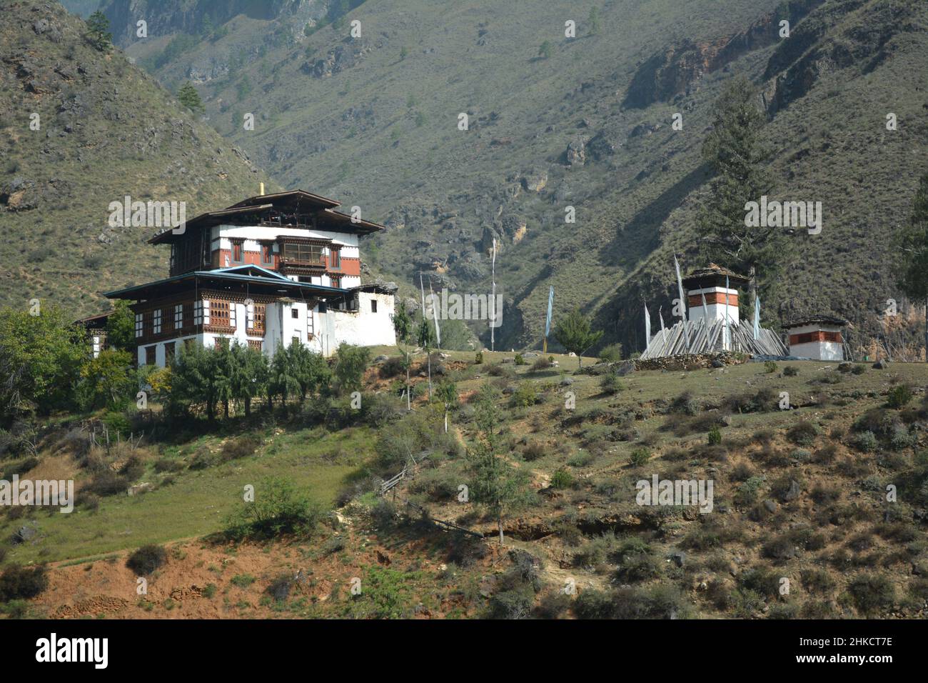 Bhutan - una scena molto bella con una casa tradizionale lungo la strada al di fuori delle città Foto Stock