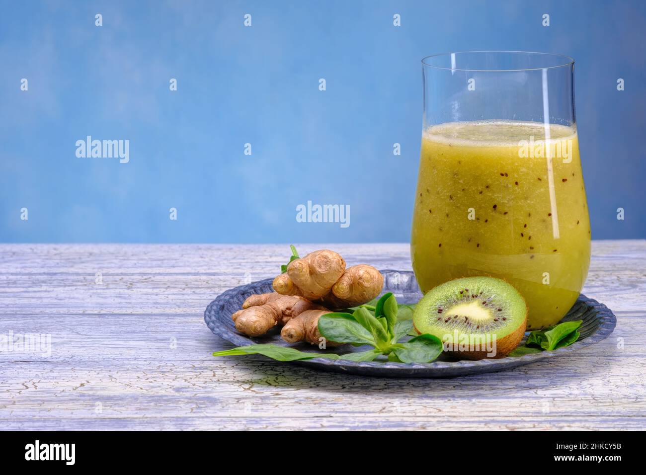 Bicchiere di spinaci verdi, arancia, zenzero e kiwi sani frullati. Foto Stock