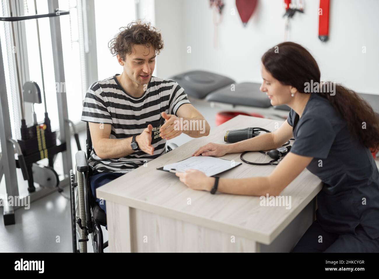 Specialista riabilitazione consulente uomo in sedia a rotelle prima della formazione Foto Stock