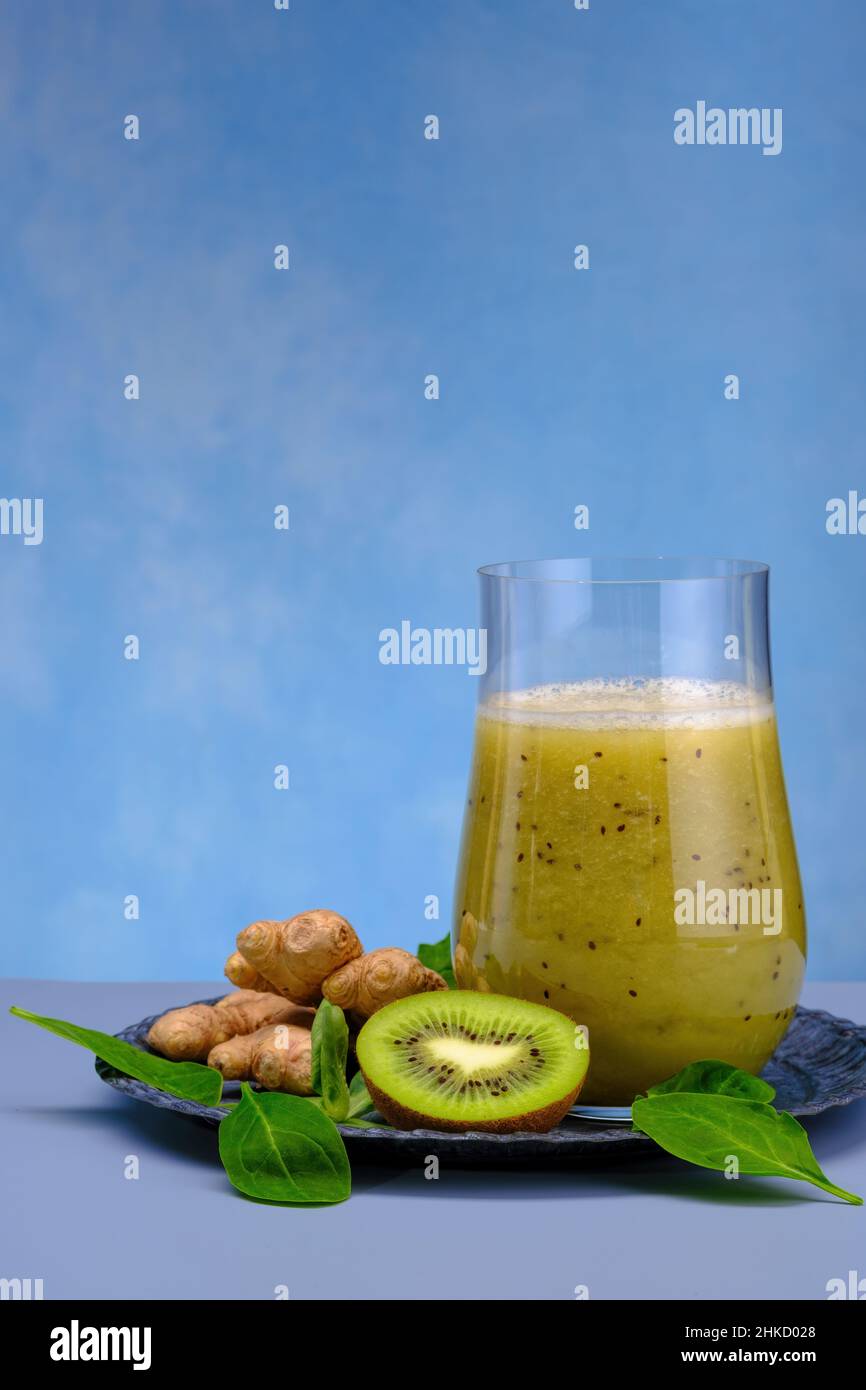 Bicchiere di spinaci verdi, arancia, zenzero e kiwi sani frullati. Foto Stock