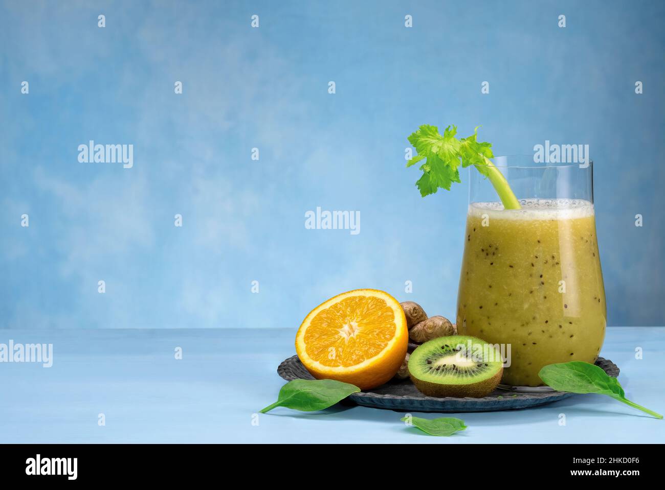 Bicchiere di spinaci verdi, arancia, zenzero e kiwi sani frullati. Foto Stock