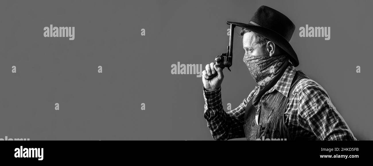 Ritratto di cowboy. Bandito americano in maschera, uomo occidentale con cappello. Ritratto di cowboy in cappello. Ritratto di uomo che indossa cappello da cowboy, pistola. Ritratto di a. Foto Stock