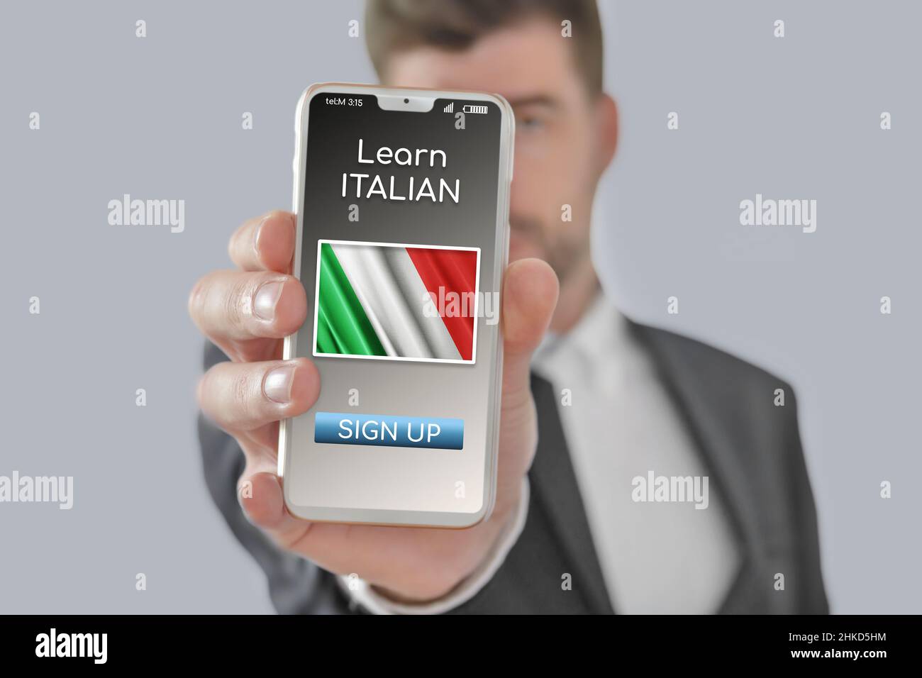 Concetto online imparare la lingua italiana con una persona che mostra l'applicazione e-learning sul cellulare con la bandiera d'Italia isolata Foto Stock