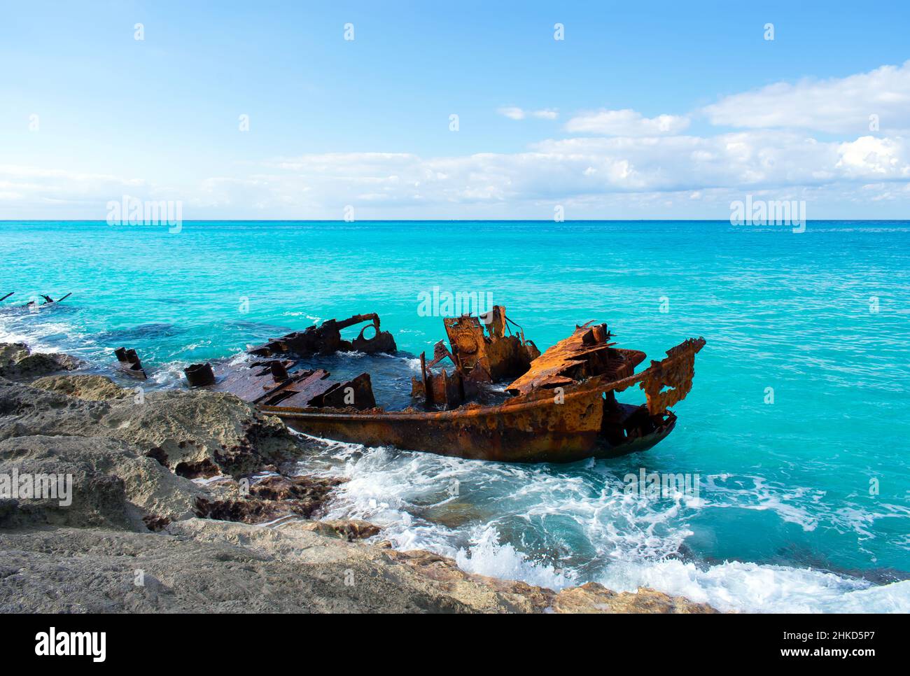 Il blu brillante dell'Oceano Atlantico brilla in modo brillante contro il relitto arancione e arrugginito della Gallant Lady a Bimini Nord, Bahamas. Foto Stock