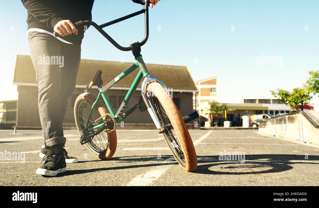 Portandolo per le strade. Scatto ritagliato di un biker BMX maschio irriconoscibile all'esterno. Foto Stock