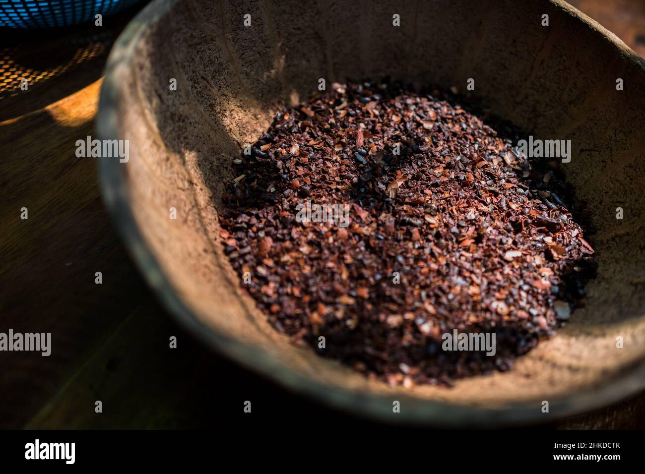 I fagioli di cacao tritati grossolanamente sono visti depositati in una ciotola nella fabbricazione artigianale del cioccolato in Xochistlahuaca, Guerrero, Messico. Foto Stock