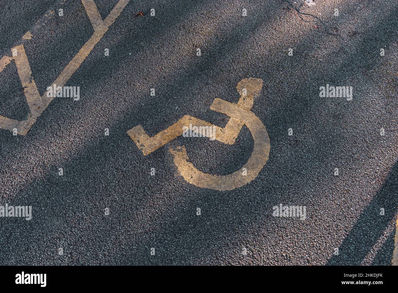 Parcheggio per disabili. Parcheggio accessibile con sedia a rotelle. Badge blu. Cartello giallo per sedie a rotelle a terra Foto Stock
