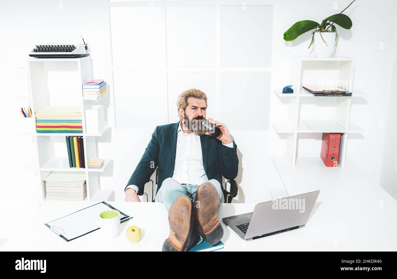 Uomo manager uomo d'affari ha lavorato con successo e alla fine della giornata, bevande birra. Foto Stock