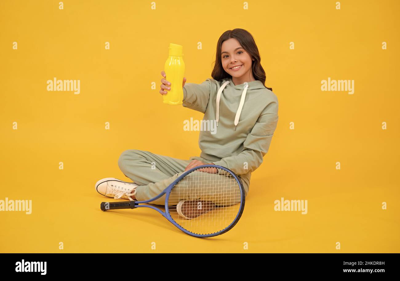 bambino con racchetta da tennis. ragazza teen beve acqua dopo l'allenamento sportivo. giocatore di badminton relax. Foto Stock