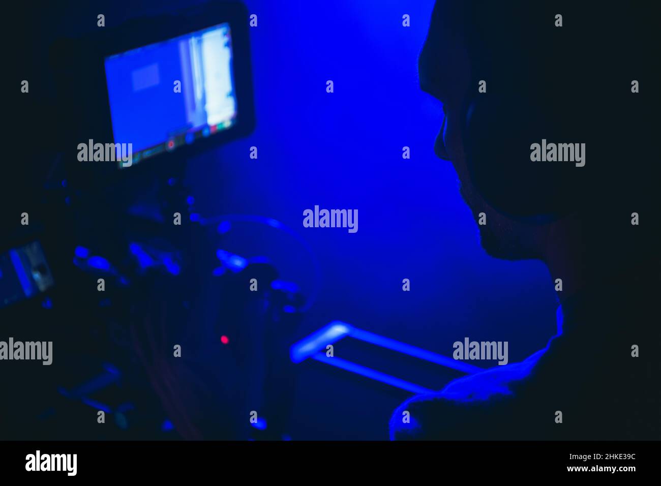 Produzioni televisive e Digital Motion Picture Theme con Caucasian Camera Operator nel suo 40s dietro l'obiettivo primo piano. Foto Stock