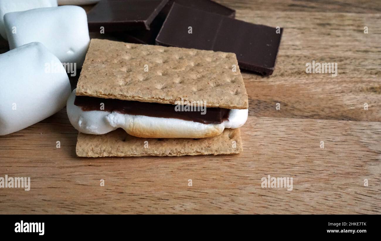 Fare s'Mores - cioccolato, marshmallows, e cracker graham su uno sfondo di legno. Foto Stock