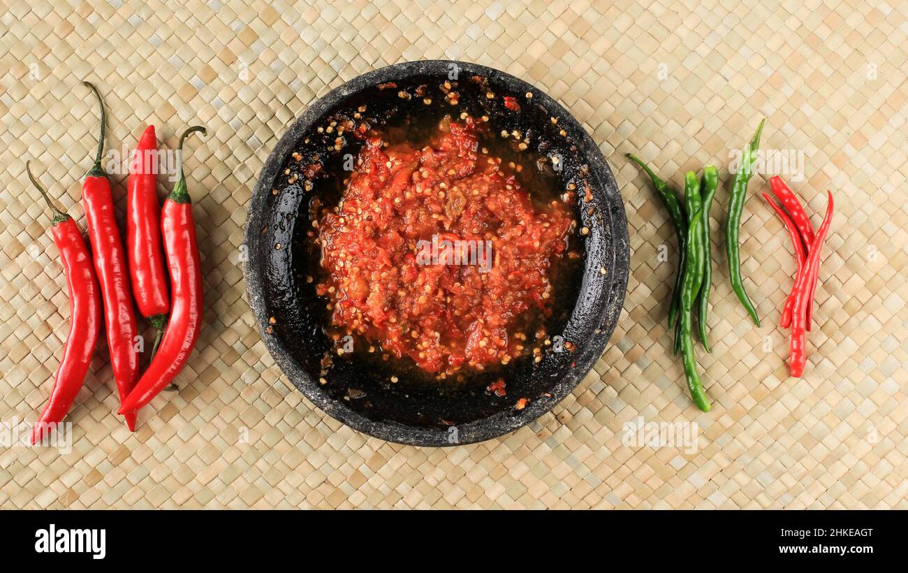 Pasta al peperoncino o Sambal, vista dall'alto con peperoncino rosso su tappeto tessuto. Concetto di cibo piccante Foto Stock