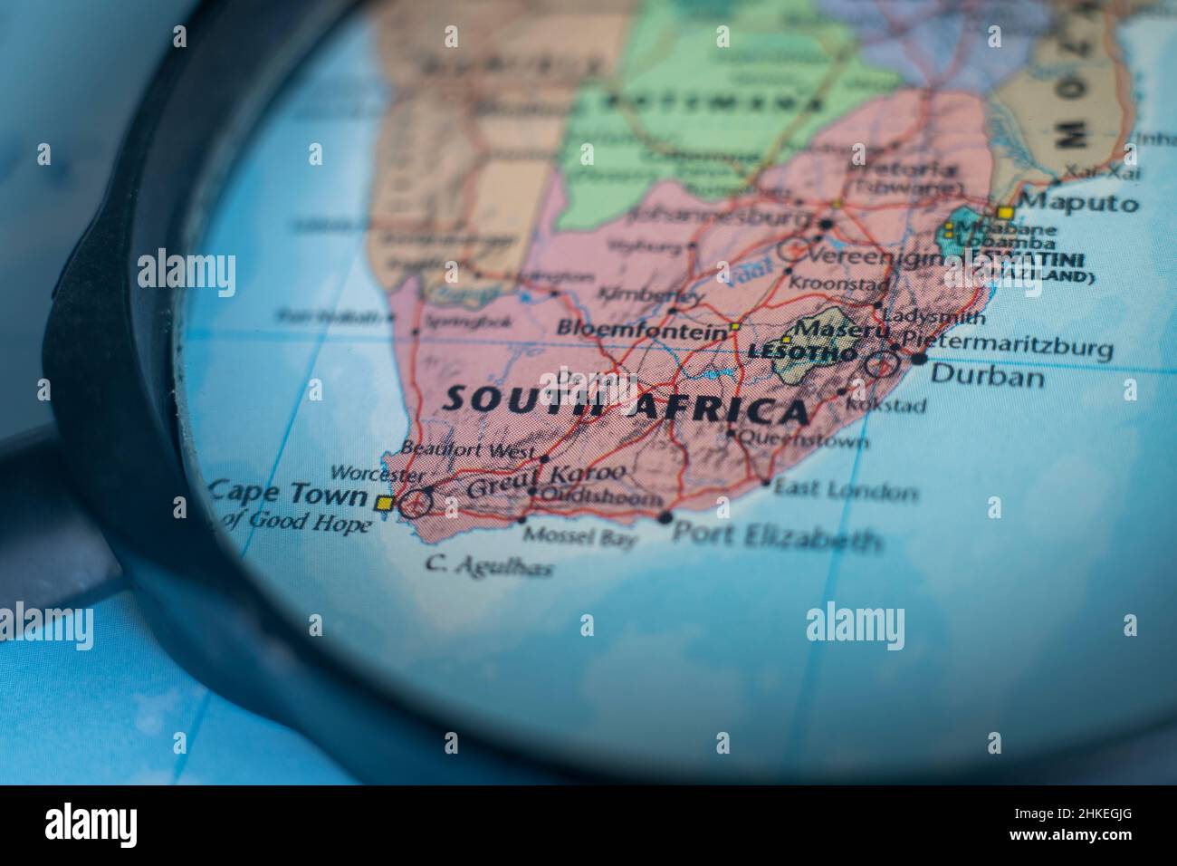 Il Sud Africa su una mappa del mondo attraverso una lente d'ingrandimento. Repubblica del Sud Africa viaggio destinazione pianificazione bloccato Foto Stock