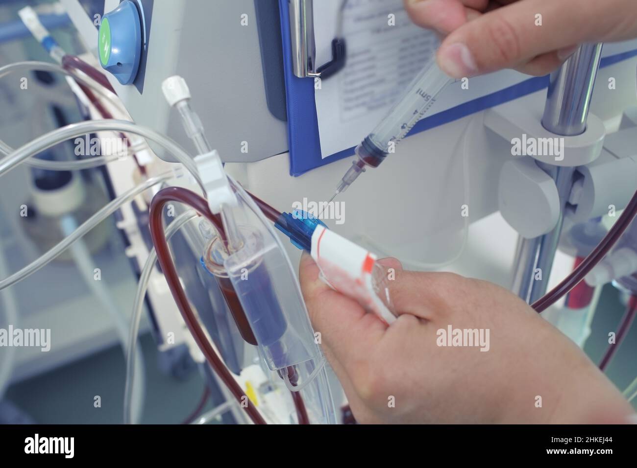 Il medico preleva il campione di sangue dal tubo di dialisi. Foto Stock