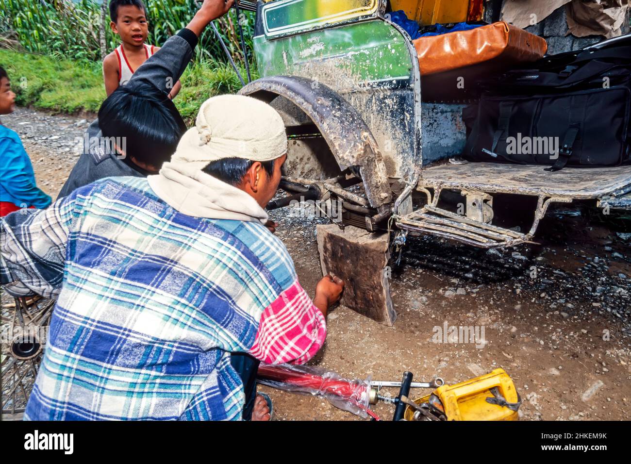 Autista filippino riparazione foratura su moto con sidecar su strada rurale, Banaue, Ifugao, Filippine Foto Stock