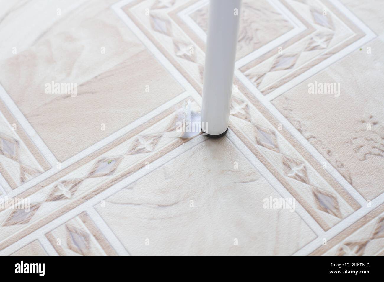 Linoleum strappato. Gamba sedia e linoleum lacerato. Foro nel linoleum. Sedia sul pavimento. Tracce di utilizzo di rivestimenti per pavimenti. Resistenza all'usura. Protezione agai Foto Stock