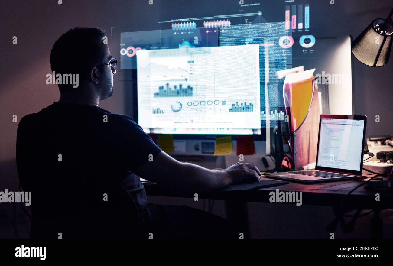 Integrazione di nuovo codice. Scatto ritagliato di un giovane programmatore di computer che guarda attraverso i dati. Foto Stock