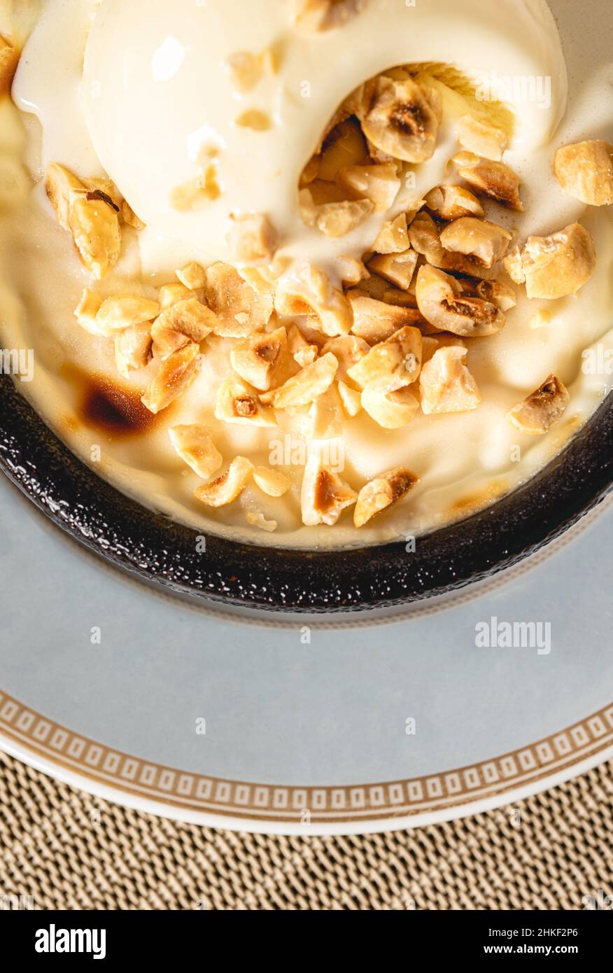 Sutlac Turco o Pudding di riso al forno con nocciole in ciotola di argilla. Foto Stock